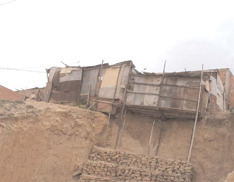 Algunas de las casas en Los Cerros del Sur están apuntaladas con vigas de madera ante el deslizamiento de la ladera que se erosiona. Un terremoto en el área sería desastroso.