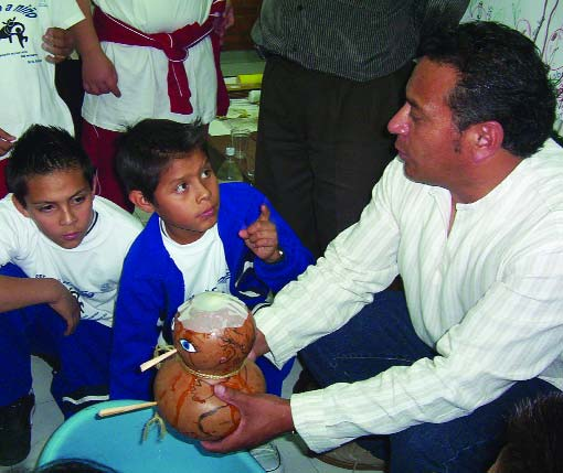Estos niños están aprendiendo a enseñar usando la calabaza bebé. El bebé de calabaza ilustra cómo se pierde líquido cuando un niño tiene diarrea, y cuánto se necesita volver a poner para prevenir la deshidratación severa.