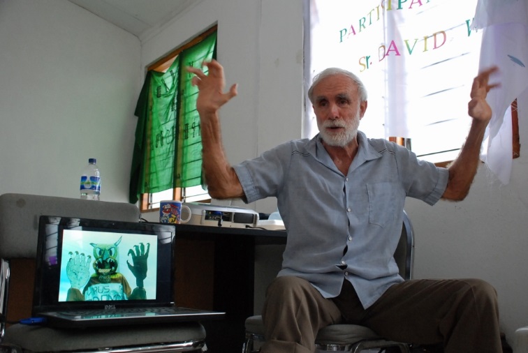 La baja tasa de vacunación en Timor provocó una reciente epidemia de sarampión. Aquí David Werner le muestra al equipo SHARE una obra de teatro callejero en Nicargua, en la cual el "Monstruo del sarampión" ataca a niños no vacunados.