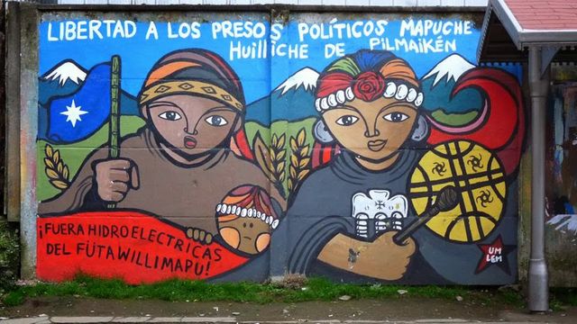 Esta pancarta exige la liberación de los presos políticos Mapuche, pero también el cierre del gran proyecto hidroeléctrico en el territorio reclamado por los Mapuche.
