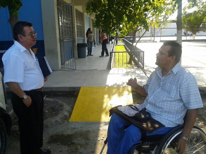 Aquí Rigo habla con un profesor frente a una de las muchas rampas que construyó la universidad en respuesta a la movilización de estudiantes discapacitados para una mejor accesibilidad.