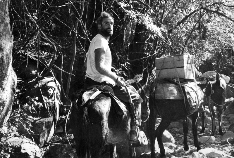 David Werner riding on a donkey, transporting medicines.
