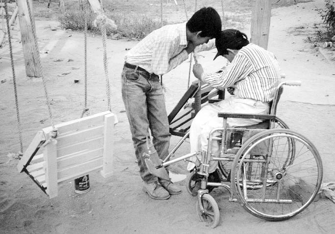 A schoolboy helps Jesús, who is almost blind, to paint the swings in PROJIMO's Playground for All Children. (See more on Jesús in Chapters 16 and 45.)