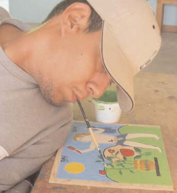 Gabriel Cortez enjoys painting fine details at PROJIMO's toy-making workshop.