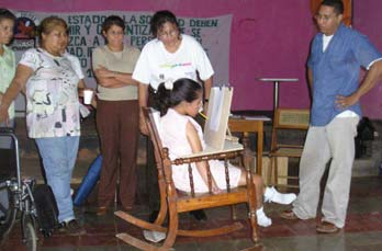 Then, to fit on the armrests, they built a tray with an adjustable stand: vertical for her to draw (and learn to read and write)...