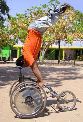 Now Jesus Orosco, who has spina bifida, is almost blind, and has lost one leg, provides a new image of "Look at my strengths, not my weaknesses." Here he stands on his arms on the racing wheelchair he helped make at PROJIMO.