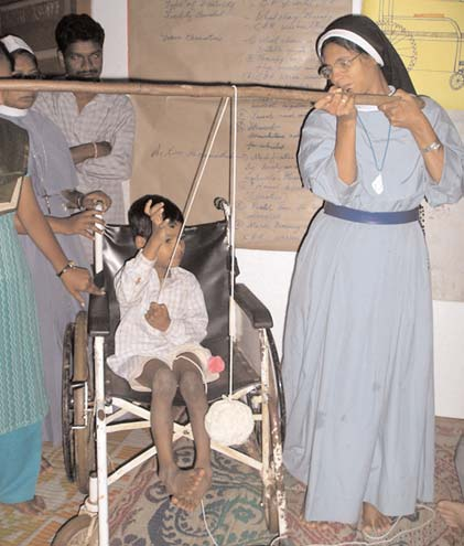 In a Community Based Rehabilitation Workshop in India, participants invented a game to help Jayaram learn to use his spastic hand. In order to lift the ball of yarn he has to use both hands. To read more about how participants made low cost aids to help Jayaram sit more comfortably in his huge wheelchair, and also learn to walk. (See above.)