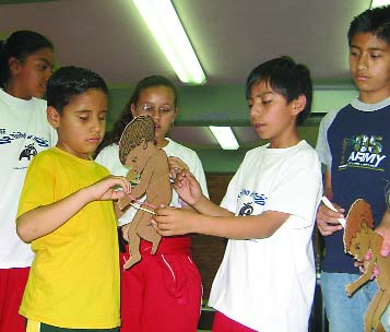 The children helped the blind boy, Melchor, measure the arm thickness of a cardboard child. Since he can’t see, instead of a colored measuring strip, he uses a string with knots to mark when a child is OK, at risk, or too thin. By feeling the knots, Melchor was able to tell which children were malnourished.