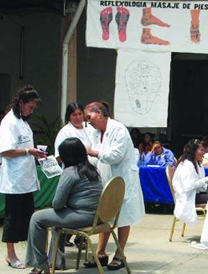 Local health promotores practice "diagnostic mapping" of the feet and ears.