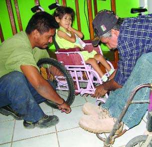 With her father's help, Raymundo makes final adjustments to a chair tailor made for this girl.