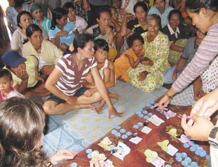 The people became very involved in the graphic "community diagnosis" in which they identified, prioritized, and explored possible solutions to their biggest health-related problems. Here they stretch string between the different problems to show which ones are often linked to or lead to others.