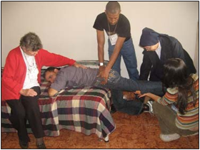 Here the mediators and León learn a good stretching exercise for the hips. Keeping one hip joint bent while they steadily lift up the other while pushing on the butt helps make sure the hip joint is stretched instead of the lower back bending.