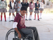 A schoolboy, Jorge, tries out riding a wheelchair.
