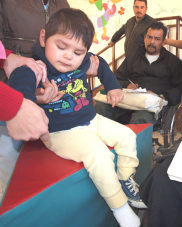 Rigo (center in wheelchair) cooperates with the Duranguito wheelchair shop in attending children who need wheelchairs—like this one being measured by Teo in Villa Juarez.