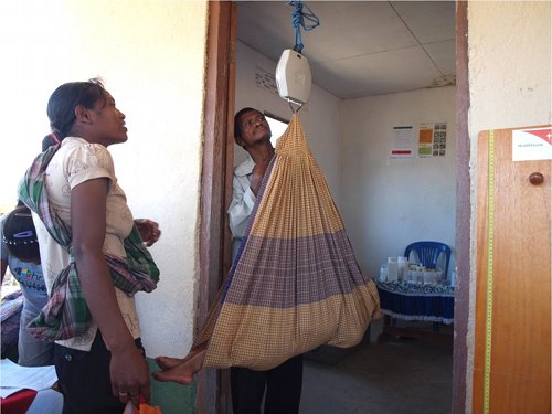 Baby being weighed using UNICEF hanging scales.