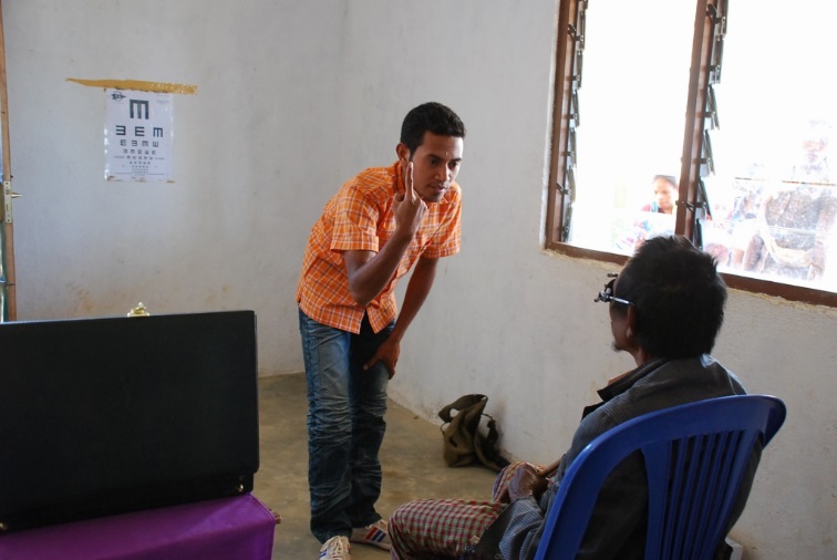 A vision technician at a SISCa event checks sight for need of glasses.