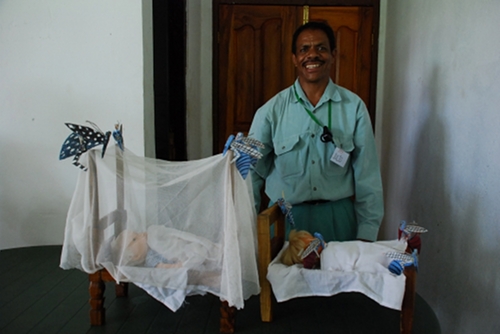 Julio from the PSF show the models he made of bed-nets and mosquitos, to show how the nets protect a child from malaria.