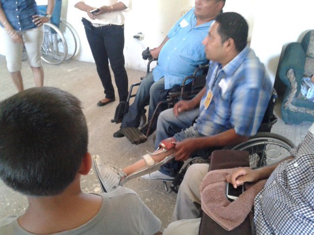 Tomás, who had polio as a young child, shows the children his leg braces, which hold his paralyzed legs straight so he can walk with crutches.