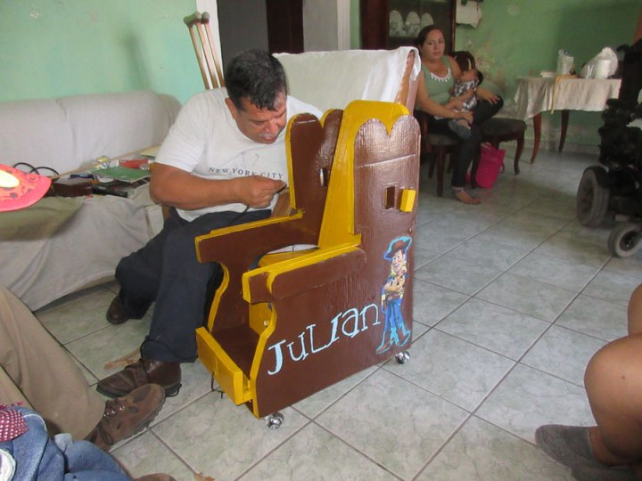 Sergio add final touches to the seat of Julian, a boy with cerebral palsy.