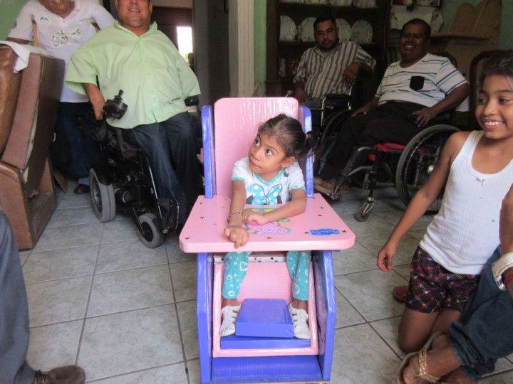 The addition of a cardboard foot separator holds her knees bent and her feet in a better position. And a pelvic belt also keeps her from thrusting forward.