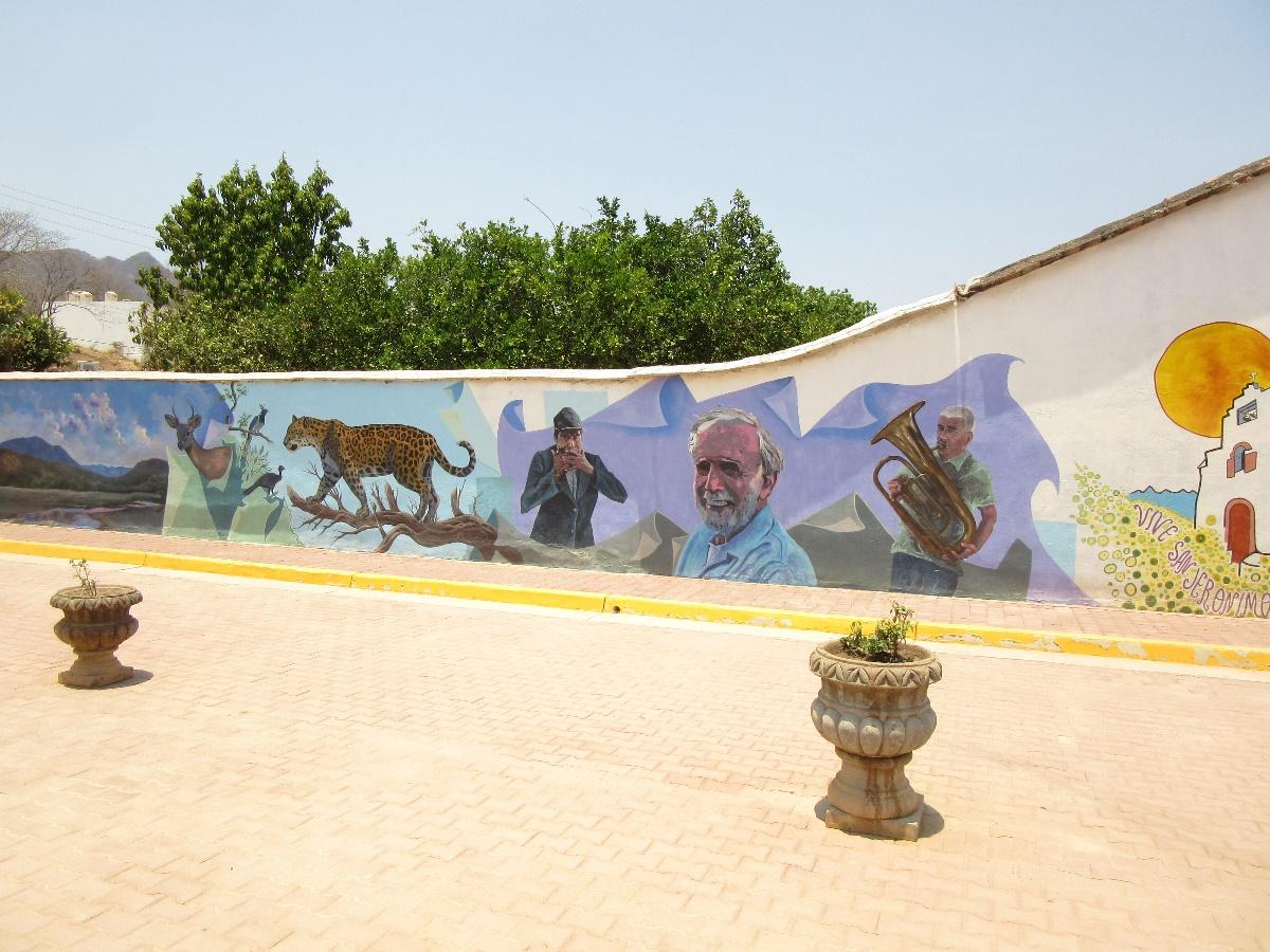 The walls bordering this new square were decorated with eye-catching murals showing local birds and animals, as well as persons who had contributed to the life of the community in recent times. Among these they included a large likeness of me.