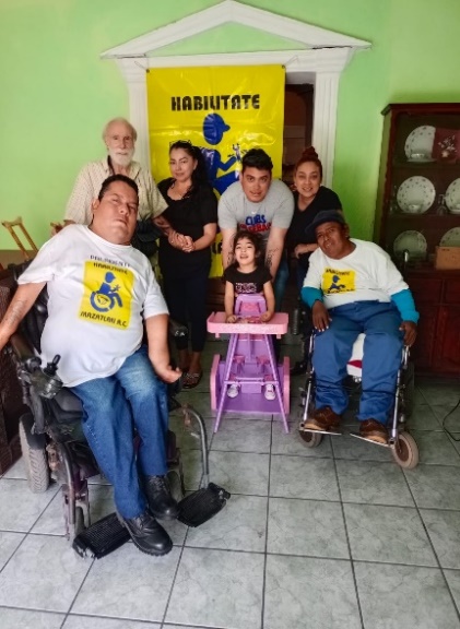 GGabriel (on left) and members of PROJIMO, with a girl born with cerebral palsy, for whom they made a standing frame to help meet her needs.